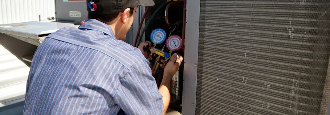 HVAC technician servicing a condenser unit in Bear Valley Springs