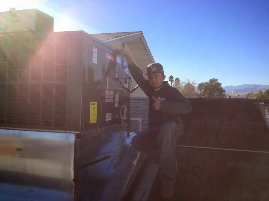 HVAC technician performing Boiler Repair on a rooftop unit in Bear Valley Springs